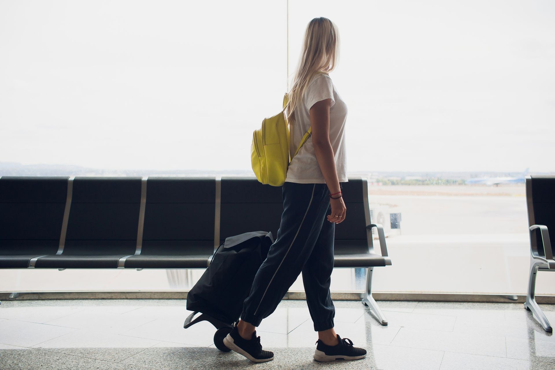 Travel business woman standing with luggage at airport.